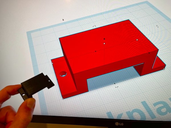 A 3D printed part in front of the model in Tinkercad